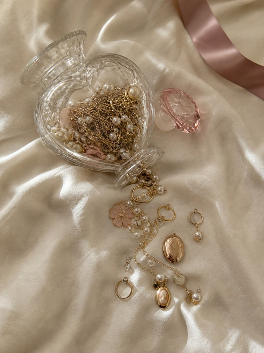 Heart shaped glass jar of jewellery on a vanity mirror tray