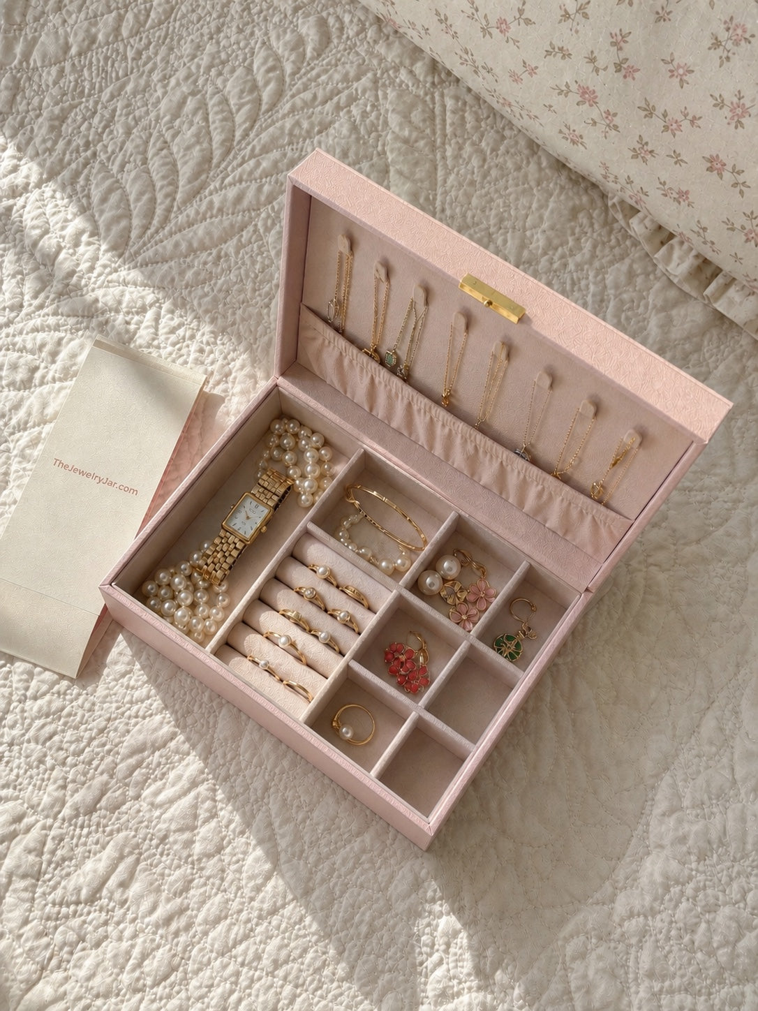 Open large pink jewelry box with organized jewelry