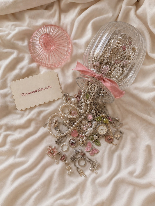 Mystery jewelry jar with pearls and charms on cream satin