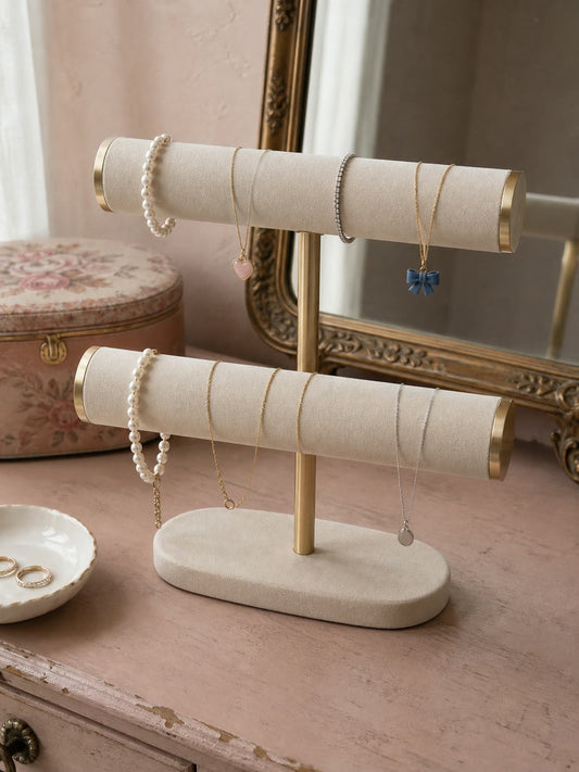Cream jewellery stand with bracelets beside a gold mirror