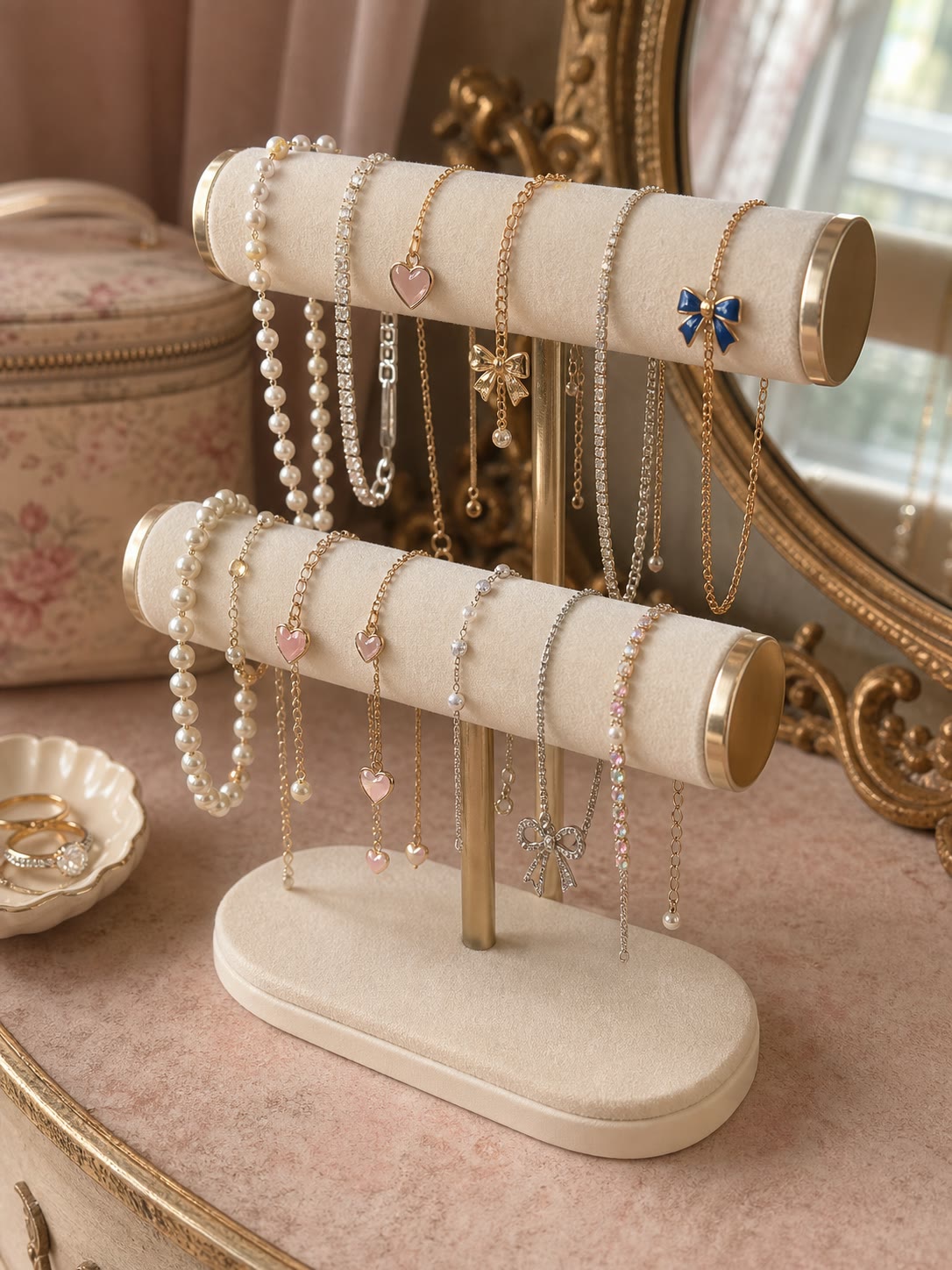 Two tier jewellery stand holding pearls and gold chains