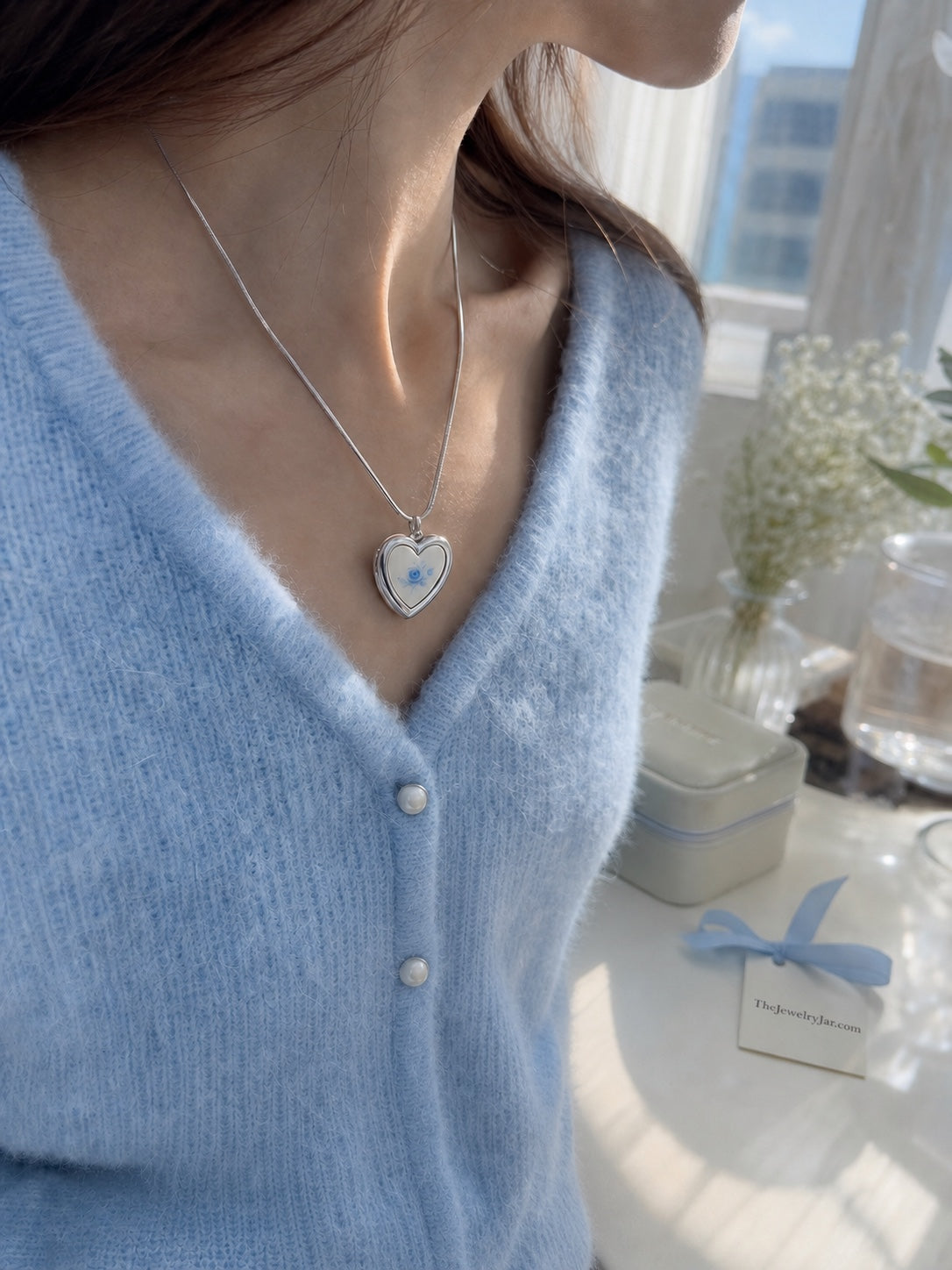 Silver blue floral heart locket worn with blue cardigan